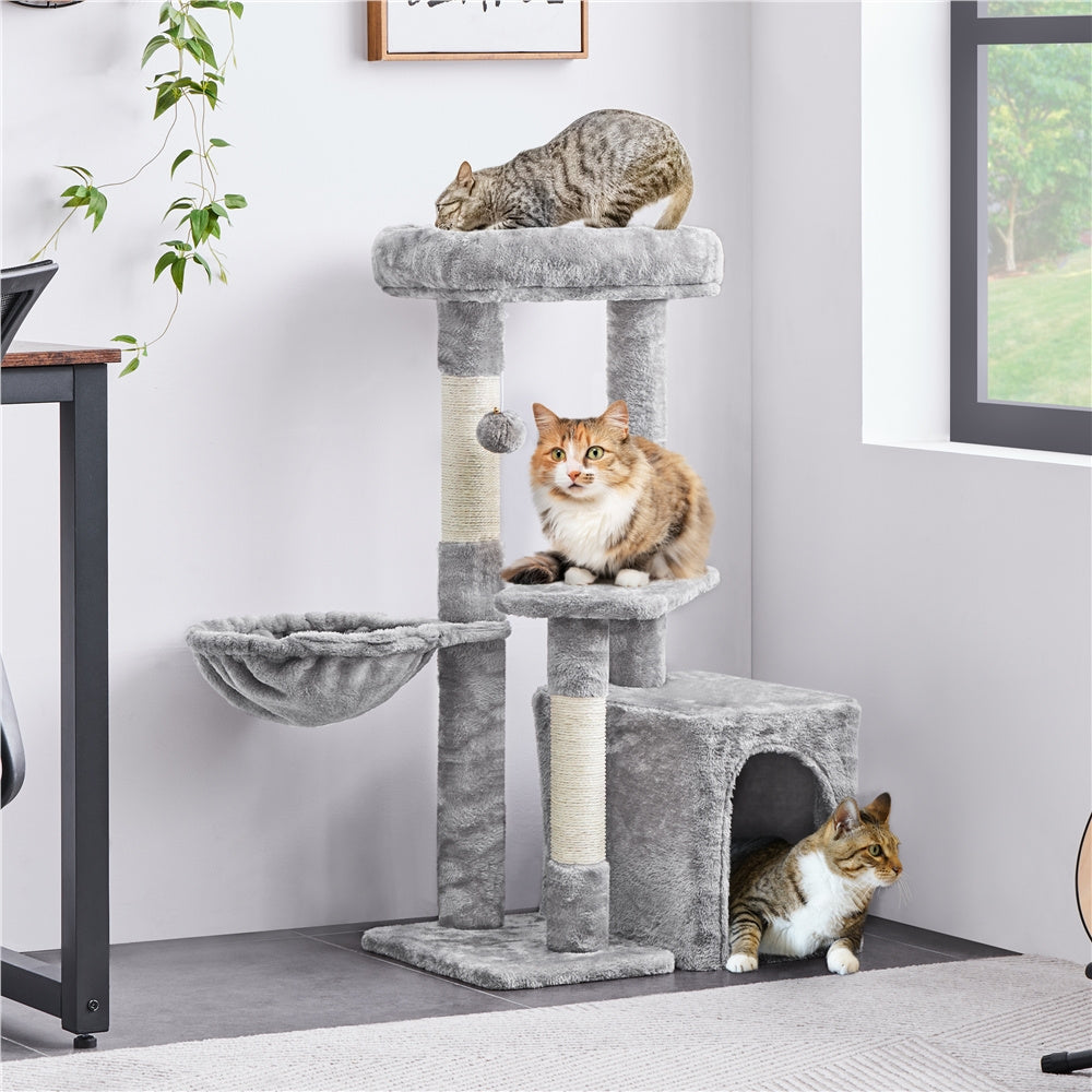 A black cat lounges on a platform of the cat tree.